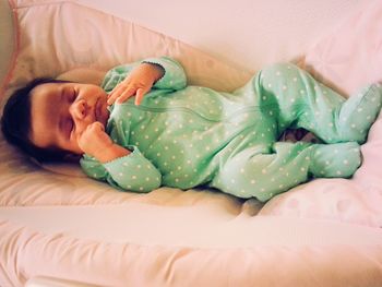 High angle view of baby girl sleeping on bed