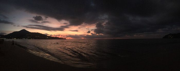 Scenic view of sea against dramatic sky during sunset