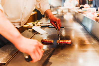 Midsection of man preparing food in kitchen