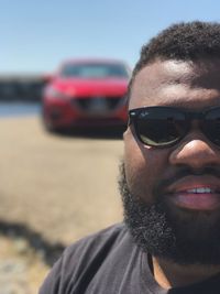 Portrait of young man wearing sunglasses against sky