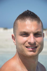 Close-up portrait of shirtless man at beach