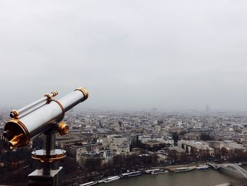 Hand-held telescope against cityscape