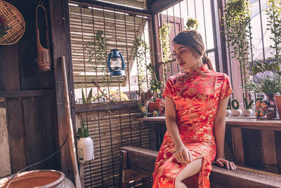 Young woman sitting by window