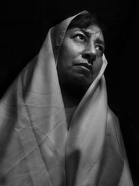 Portrait of young man against black background