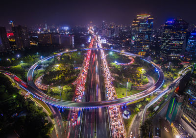 High angle view of illuminated street amidst buildings at night