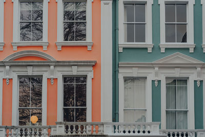 Close up of orange and turquoise pastel coloured terraced houses in primrose hill, north london, uk.