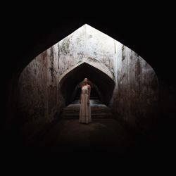 Woman looking up while standing in tunnel