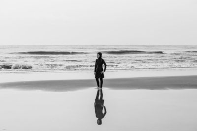 Full length of man on beach against clear sky