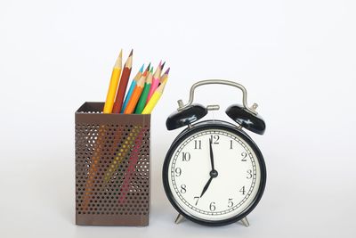 Close-up of clock on table against white background