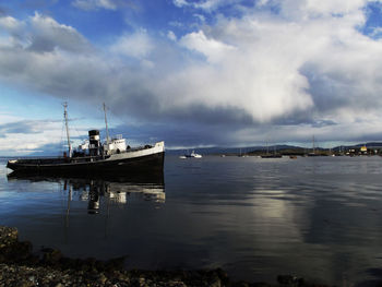 Boat moored in sea against sky