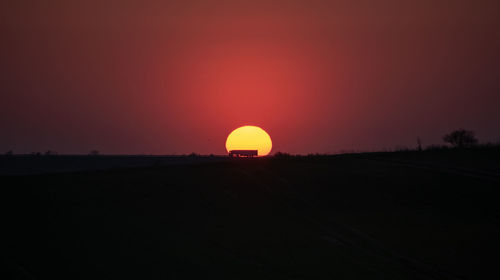 Scenic view of silhouette field against sky during sunset