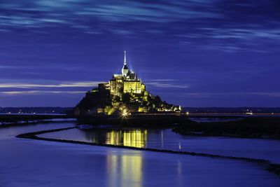 Illuminated building against sky at night