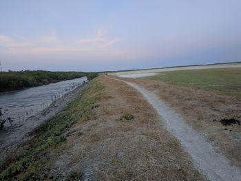 Empty road along landscape during sunset