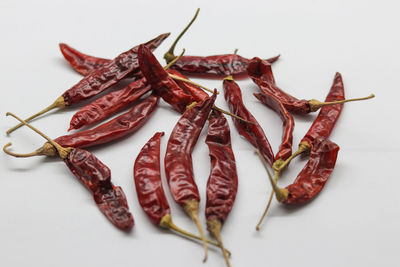 High angle view of red chili pepper against white background