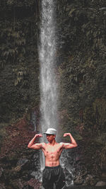 Full length of shirtless man standing in water