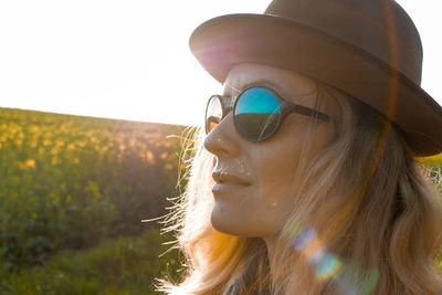 Woman in hat and sunglasses against clear sky