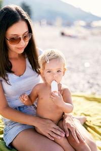 Portrait of smiling young woman sitting at beach