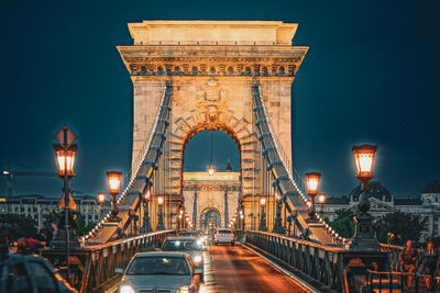 Illuminated bridge against sky at night