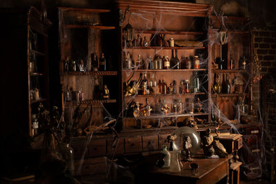 Bottles on shelf with spider web