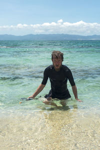 Portrait of man walking in sea at beach