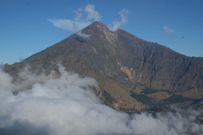 Scenic view of volcanic mountain against blue sky