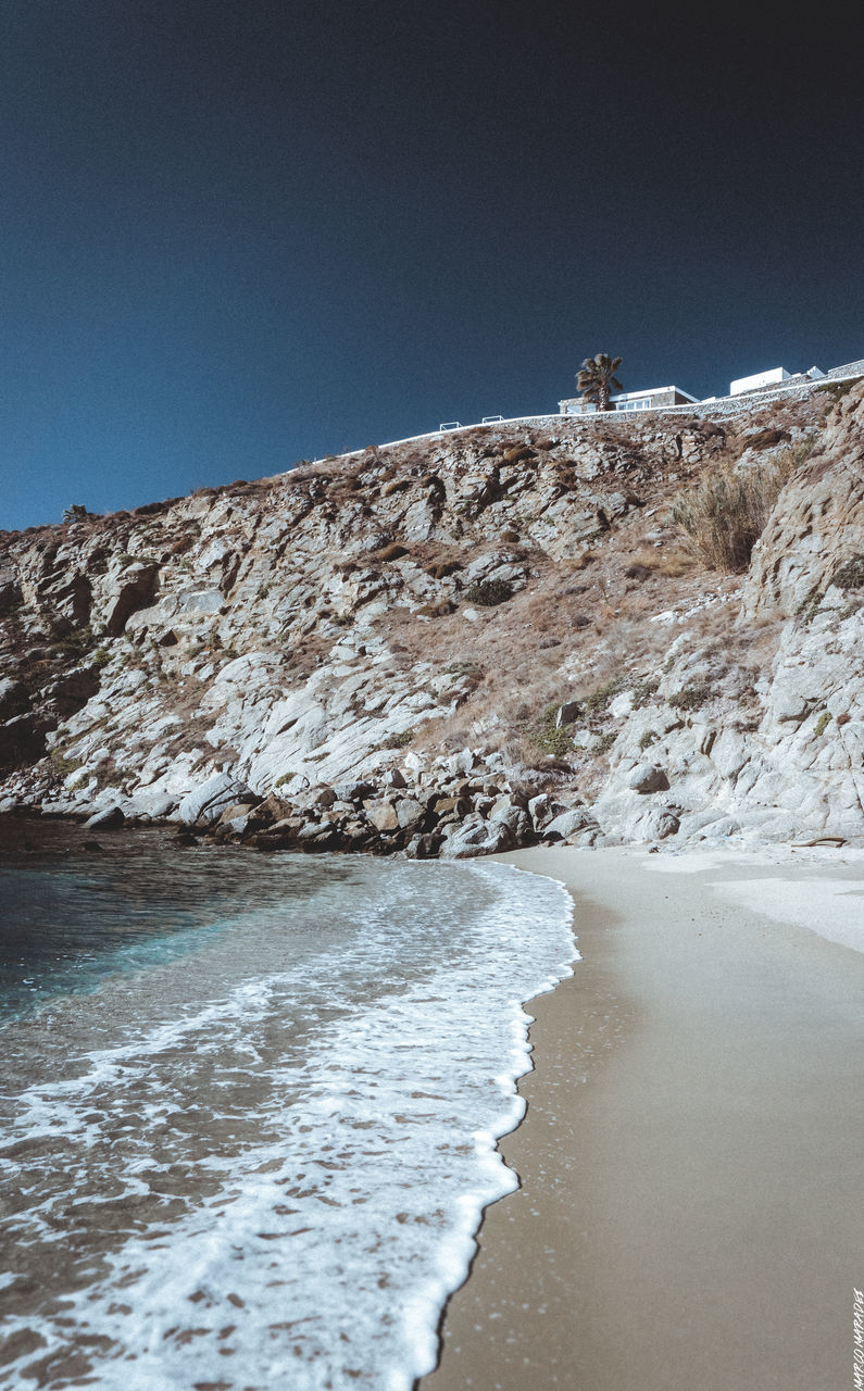 SEA BY CLIFF AGAINST CLEAR SKY