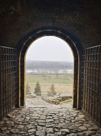 Stone wall by historic building against sky