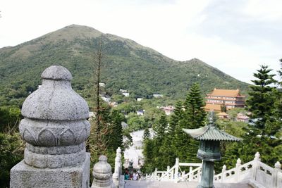 Built structure against trees and mountains against sky