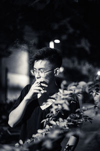 Teenage boy smoking cigarette at night