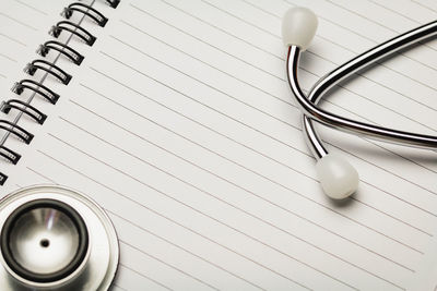 Close-up of stethoscope on spiral notebook