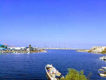 High angle view of sailboats moored in sea against clear blue sky