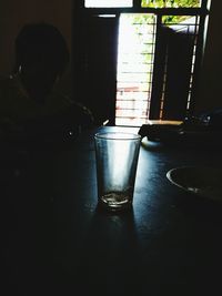 Reflection of man in drinking glass