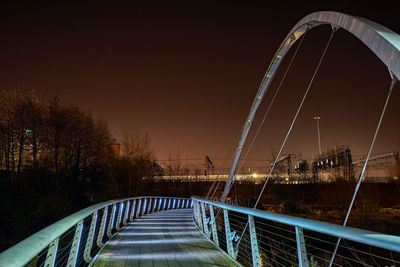 Illuminated bridge in city at night