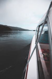 Close-up of boat sailing on sea against sky