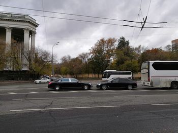 Cars on road against sky in city