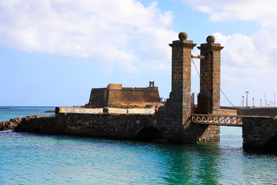 Historic building by sea against sky