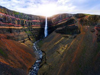 Scenic view of waterfall against sky