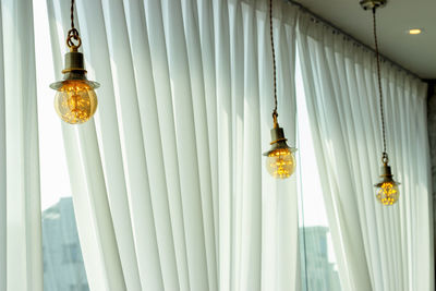 Electric lamps hang in a cafe near the window, interior details.