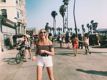 Women standing by palm trees on city street