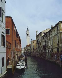 Boats in canal along buildings