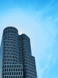 Low angle view of skyscraper against blue sky