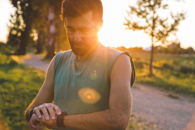 Young man looking away while standing on land