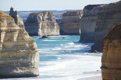 Scenic view of cliff by sea against sky