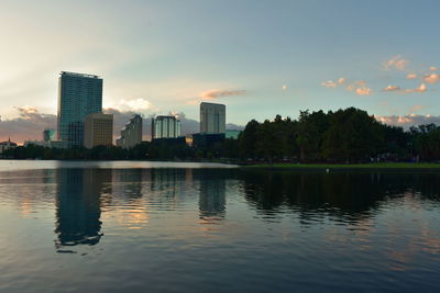 Scenic view of lake by buildings against sky