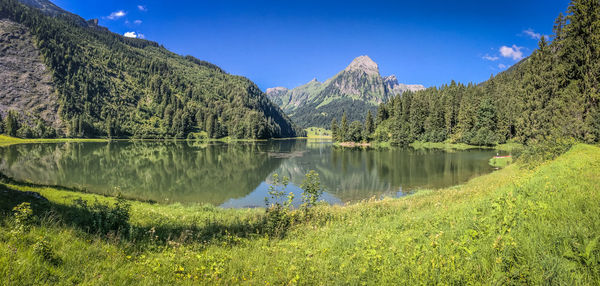 Scenic view of lake by mountains against sky