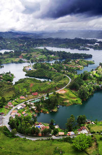 Scenic view of river and green landscape against sky