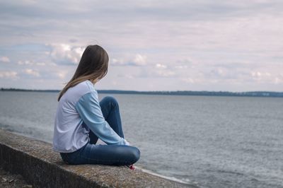 Woman looking at sea against sky