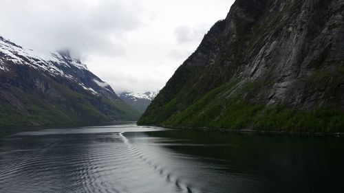 Scenic view of fjord amidst mountains against sky