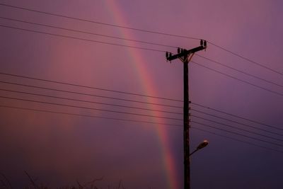 Rainbow and an electricity pylon against sky