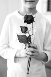 Midsection of woman holding flowering plant